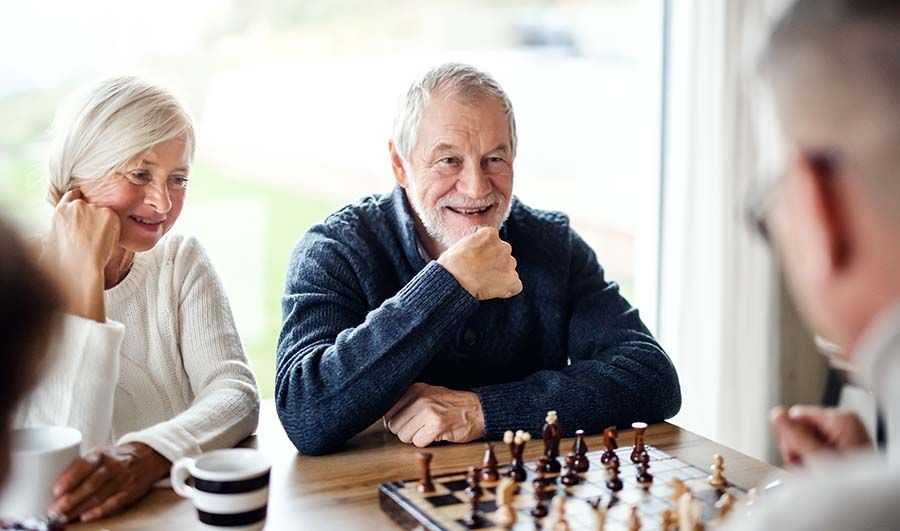 Ein älterer Mann spielt Schach mit jemandem.