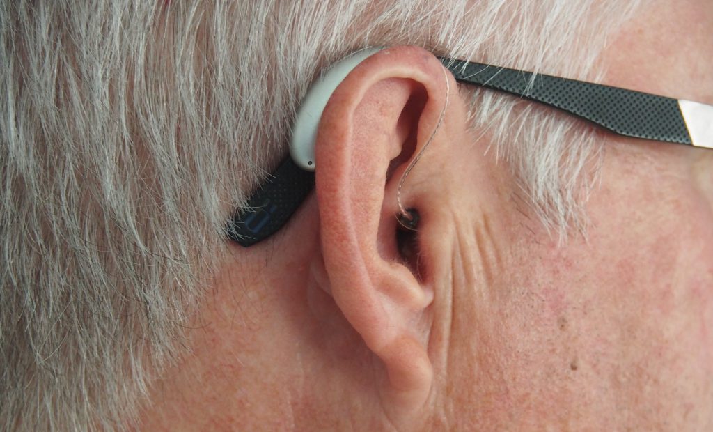 Ein Mann ist sichtbar mit einem Hörgerät im Ohr.